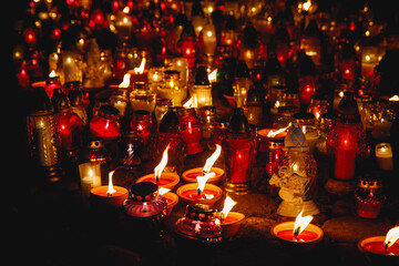 Many colorful lit memory candles in the dark. A beautiful display of colorful candles glowing in...