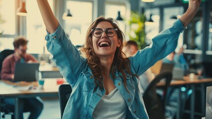 Startup young woman very happy and excited doing winner gesture with arms raised sitting on chair...