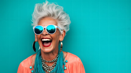 Laughing senior woman against turquoise wall  background