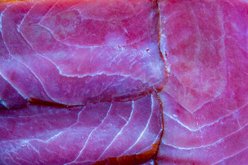 Cold smoked tuna fillet slices in background, closeup, top view