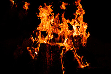 Burning fire with orange flames and dark wood