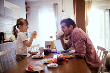 Father and daughter enjoying breakfast at home