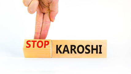 Stop karoshi symbol. Concept words Karoshi or Stop karoshi on beautiful wooden blocks. Beautiful white table white background. Businessman hand. Business and stop karoshi concept. Copy space.