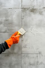Hand in Orange Glove Painting Over Concrete Wall