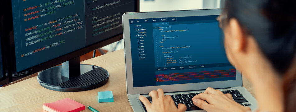 Cropped image of female web developer coding on laptop while computer displayed program and software code at modern office. Close up businesswoman hand focus on analysis data. Burgeoning.