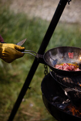Campfire cooking of food in the nature while camping in summer