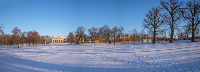 Panorama, snowy view over a winter garden and a castle in a park, on the Drottningholm island in Stockholm, Sweden