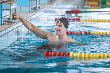 Man swimmer happy at the finish of a race in the pool at competition