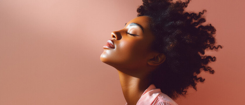 Beautiful african american woman with afro hairstyle on pink background