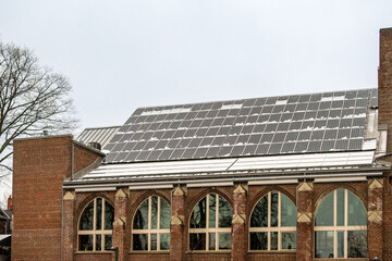 Older buildings going green to fight global warming: Solar panels generating electricity on the...