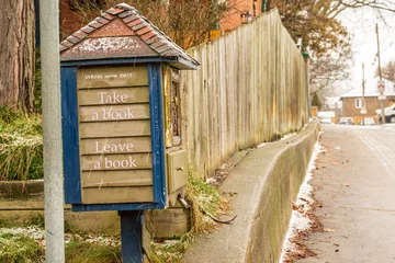Poster Take a book. Leave a book: free book exchange box (hand made) on a residential street shot on a wet winter day in the toronto beaches neighbourhood room for text © Michael Connor Photo