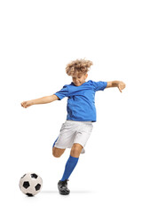 Boy in a football kit kicking a ball