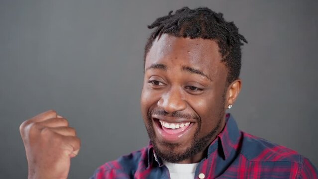 Happy african american amn says yes and gesturing on grey background.