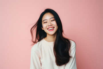 Obraz premium Portrait of beautiful young asian woman smiling on pink background .