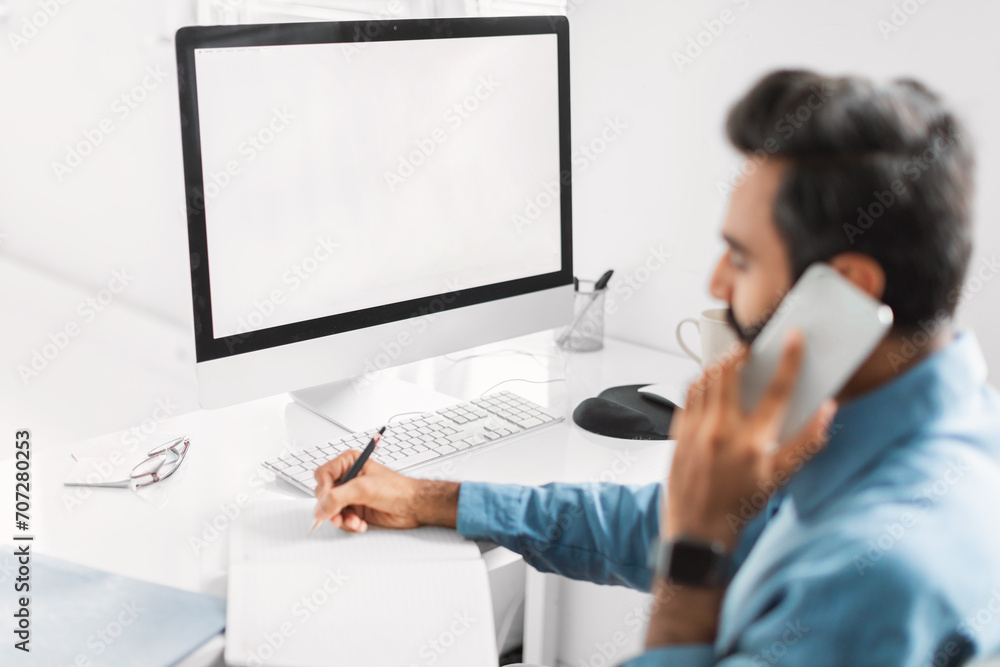 Poster multitasking man talking on phone while writing notes