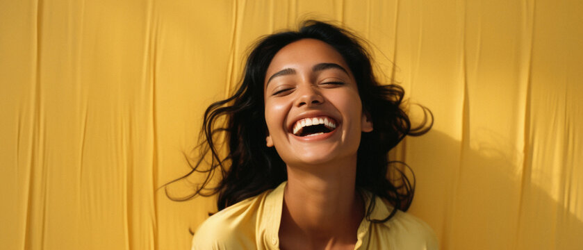 Happy Indian Woman Laughing And Looking Away On Yellow Background