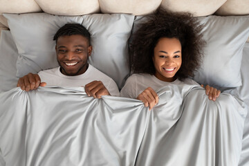 Top View African Couple Lying In Bed Covered With Blanket