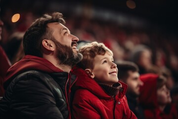 Father and son cheering in football stadium - obrazy, fototapety, plakaty