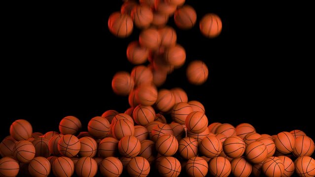 Lots of classic orange basketball balls fall on the ground on black background. Slow motion of many basketball balls
