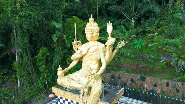 Aerial view on Gold Brahma God Statue on Jungle Desa Duda in Bali. Discover the Rich Hinduism Heritage of Asia's Vacation Destination in Indonesia.
