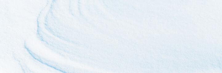 Wide panoramic winter background with snowy ground. Natural snow texture. Wind sculpted patterns on...