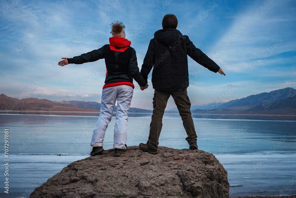 Canvas Prints Man and woman holding hands on frozen lake background in winter