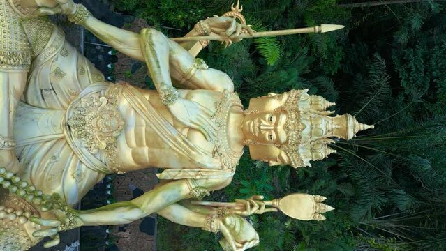 Aerial view on Gold Brahma God Statue on Jungle Desa Duda in Bali. Vertical video.