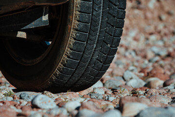 Fototapeta na wymiar Car wheel on stones close-up view