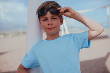 Portrait of handsome boy with sunglasses on the beach