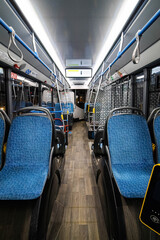 Interior of modern bus or trolleybus. Blue seats inside public transport. Handrails and ticket control system - obrazy, fototapety, plakaty