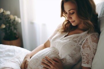 Young beautiful pregnant woman sitting on bed