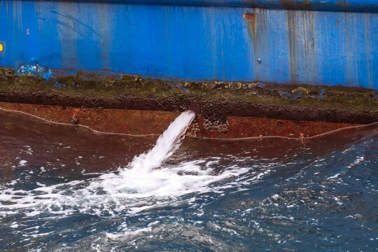 a water hose spewing out of the side of a ship © Wirestock