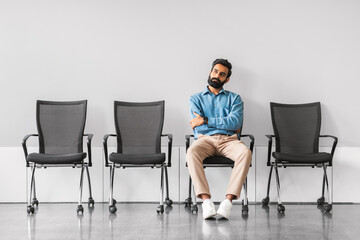 Professional indian man sitting with crossed arms in an empty meeting area