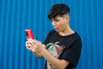 Androgynous rocker woman on the street using her smartphone