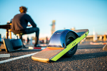 modern electric skateboard awaits its rider on sunlit urban pavement, symbolizing eco-friendly...
