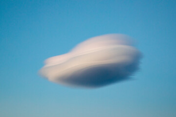 White lenticular clouds against a blue sky background