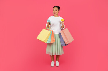 Smiling asian shopper woman with shopping bags, smartphone, and credit card