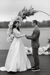 the first wedding dance of the bride and groom on the pier near the river