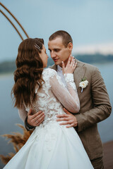 the first wedding dance of the bride and groom on the pier near the river