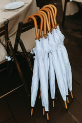 white umbrellas from rain and sun with wooden handles