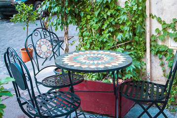 A table with green and yellow mosaic tiles in the cafe. garden furniture