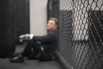 Defocused background, boxer resting, mma or mixed martial arts, sports training at gym