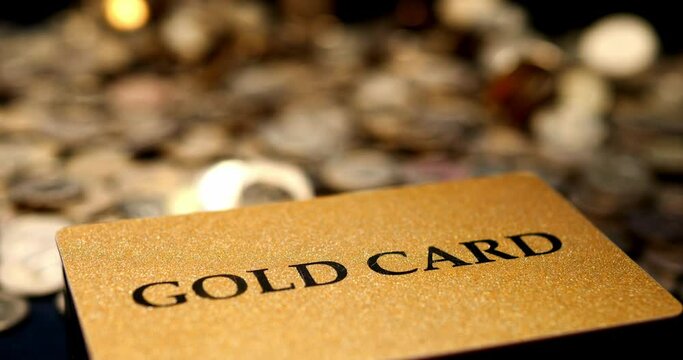 Gold card with financial savings. Card for discounts and privileges in the golden club. Accumulation and preservation of capital. Gold coins and money fall from above.
