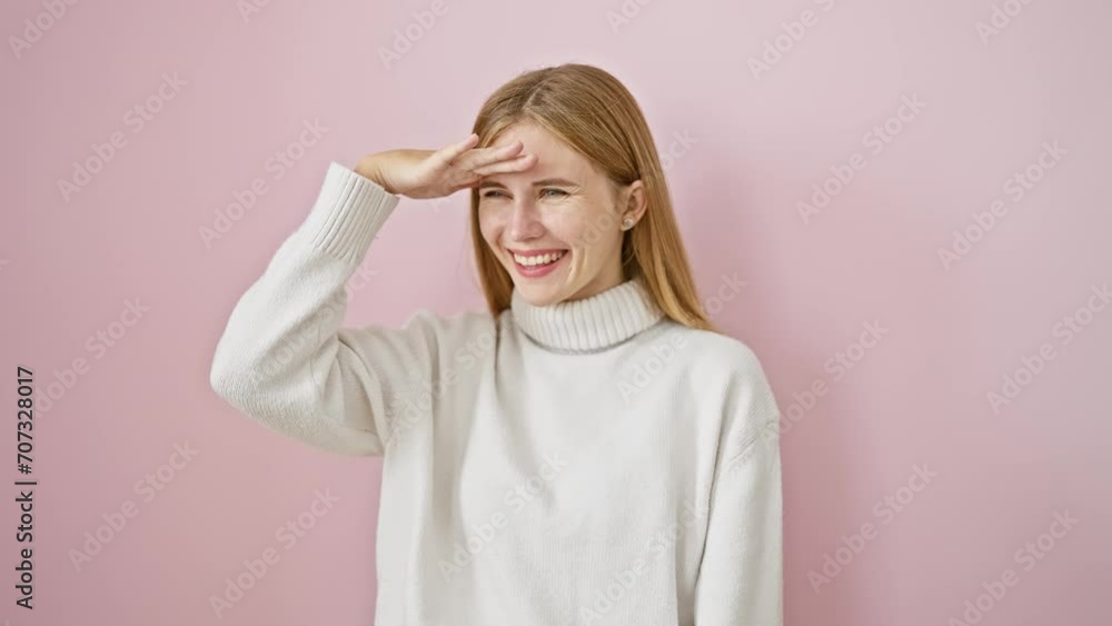 Sticker Happy, attractive blonde girl confidently posing, hand over eyes searching far away. isolated pink background framing her winter smile.