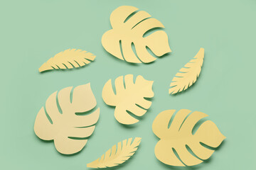 Yellow paper tropical leaves on green background