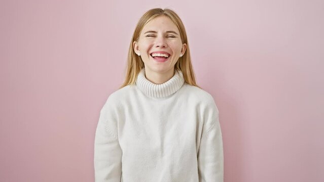 Crazy fun with beautiful blonde girl, making a comical fish face expression over a pink isolated background. standing out with her comical lips gesture.