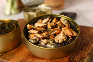 Board with opened tin can of mussels, closeup