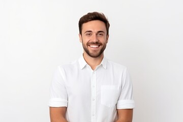 Handsome young man in white shirt looking at camera and smiling while standing against white background
