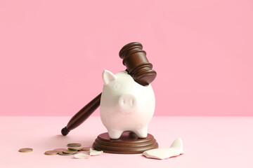 Broken piggy bank with judge gavel and money on pink background. Bankruptcy concept