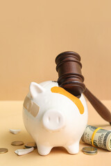 Broken patched piggy bank with judge gavel and money on orange background. Bankruptcy concept - obrazy, fototapety, plakaty